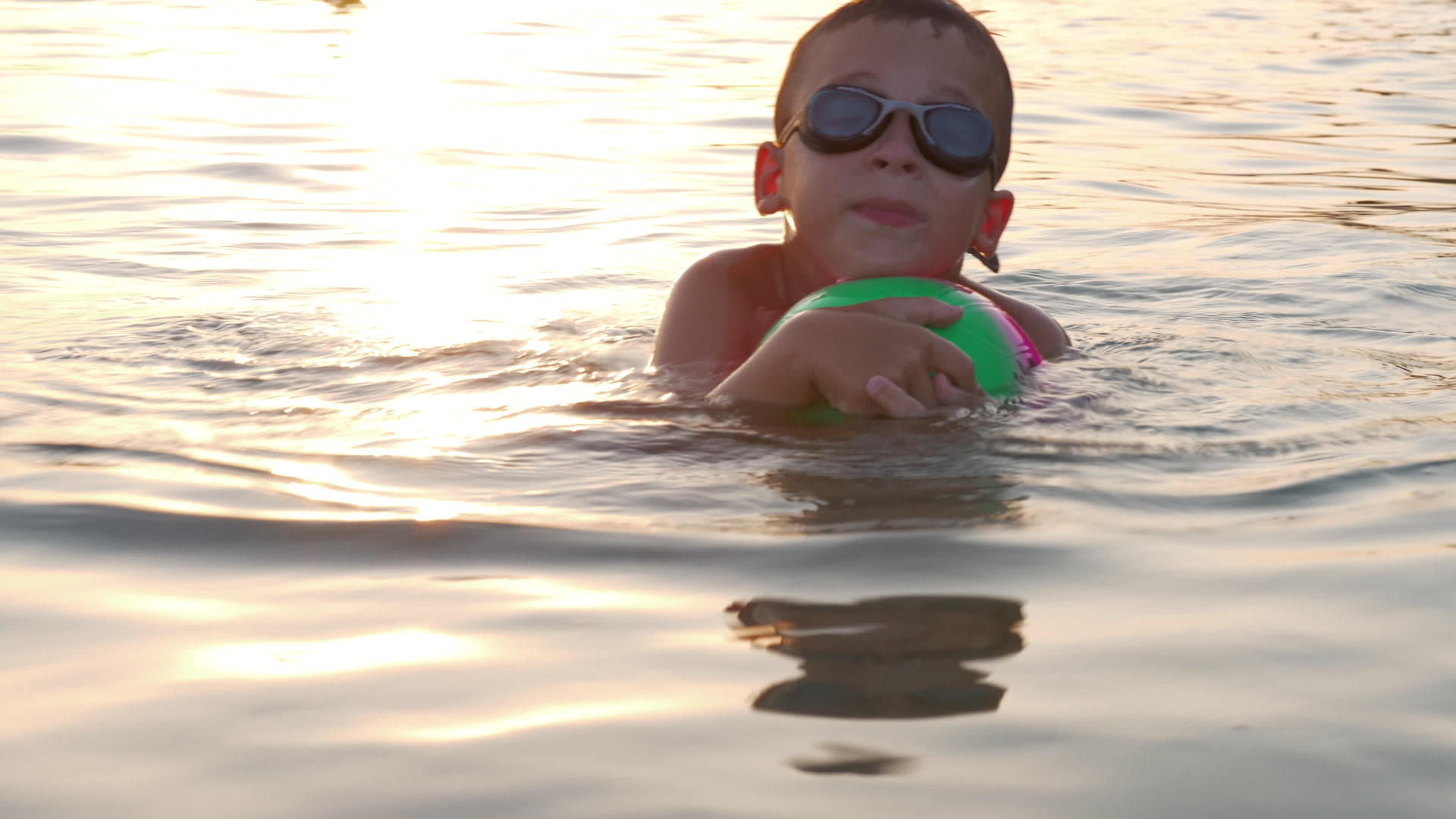 日落时在海里游泳的男孩视频的预览图