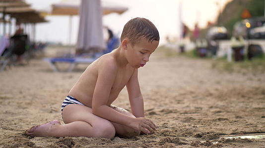 暑假期间孩子们在沙滩上玩沙子视频的预览图