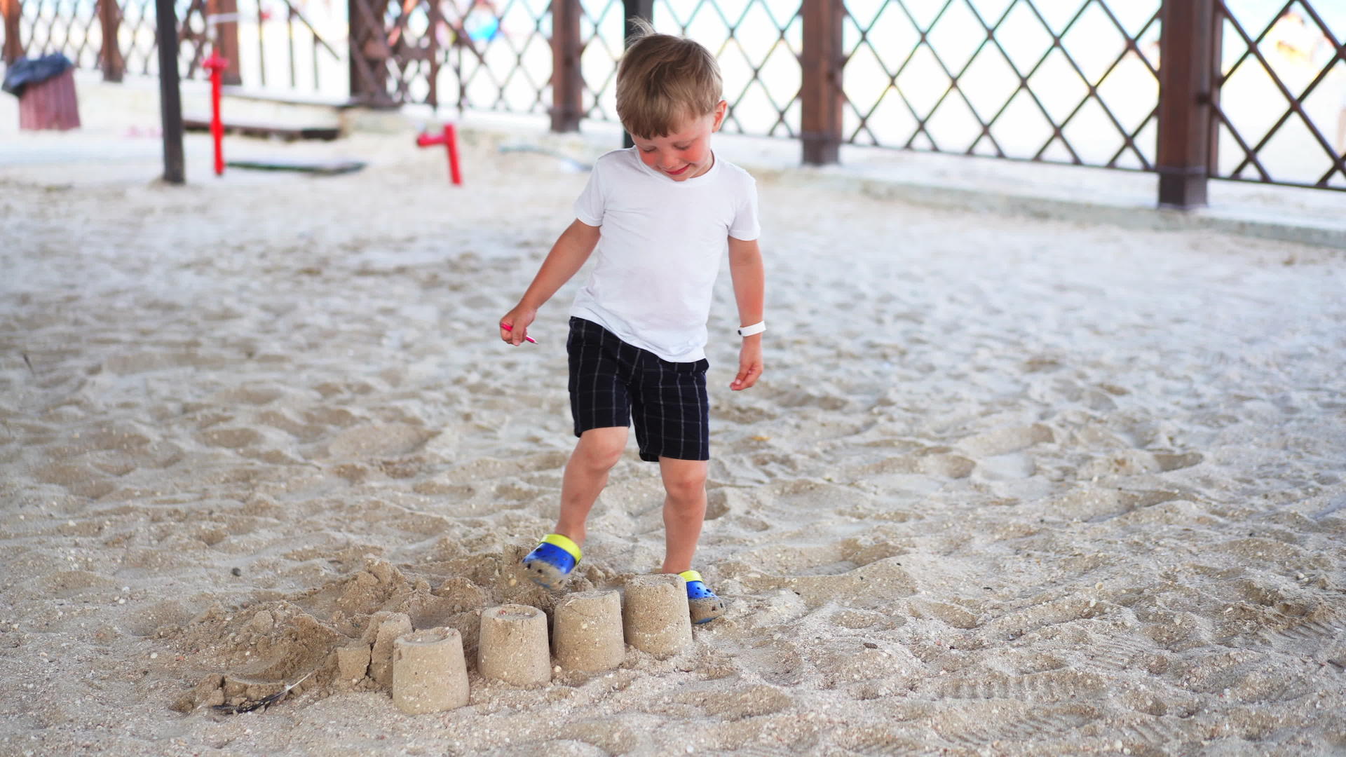 男孩摧毁海滩城堡海滩童年暑假家庭度假视频的预览图