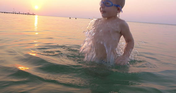 日落时戴着护目镜的孩子们在海里玩得很开心视频的预览图
