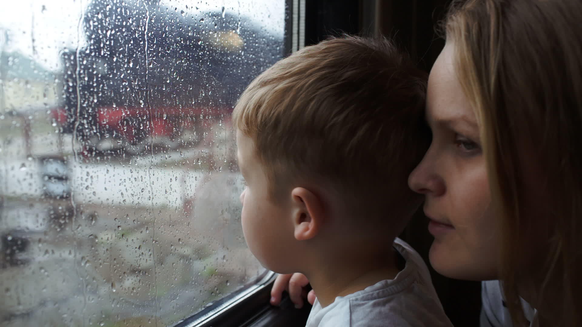 当火车下山时男孩和他的母亲抬头看着火车窗外视频的预览图