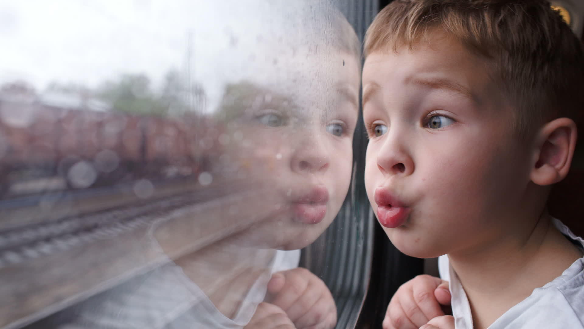 雨天看着火车窗外好奇的男孩视频的预览图