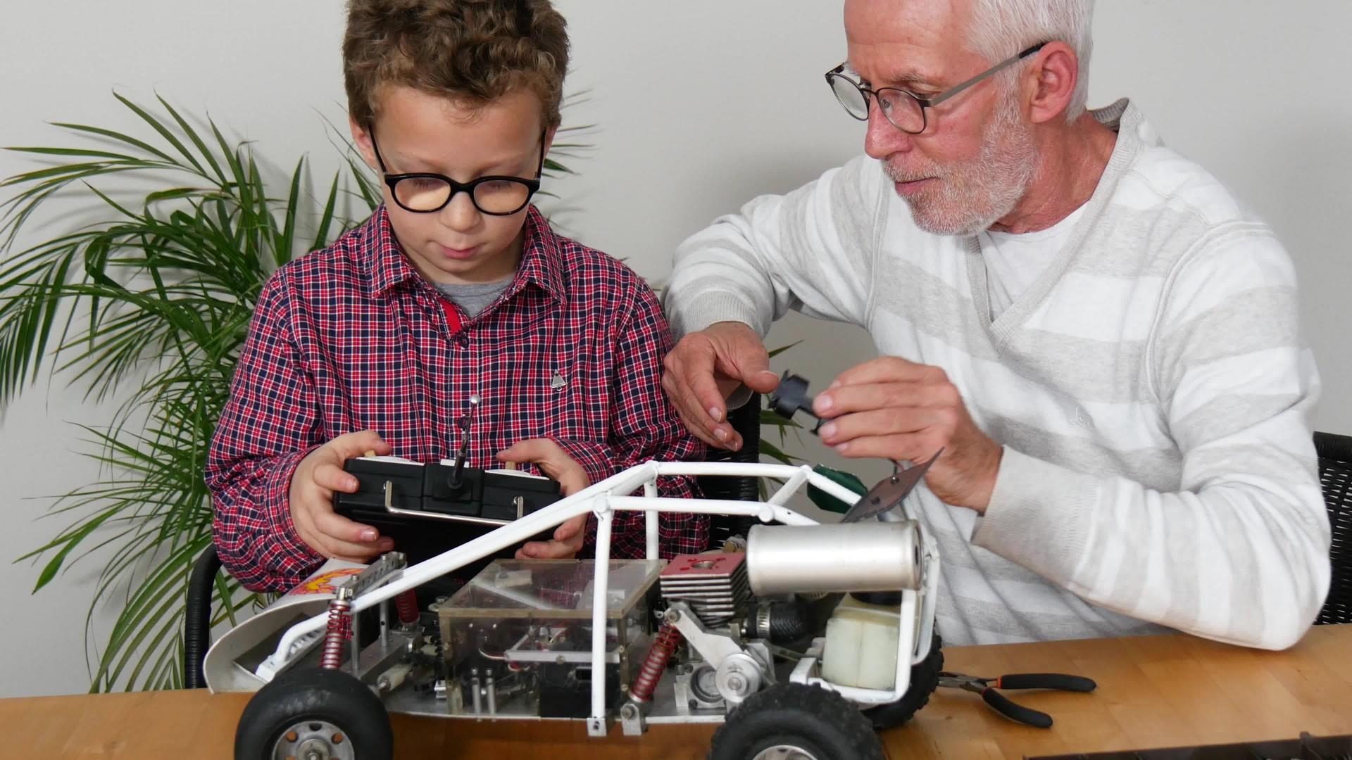 爷爷和儿子小男孩正在修理无线电控制车的模型视频的预览图