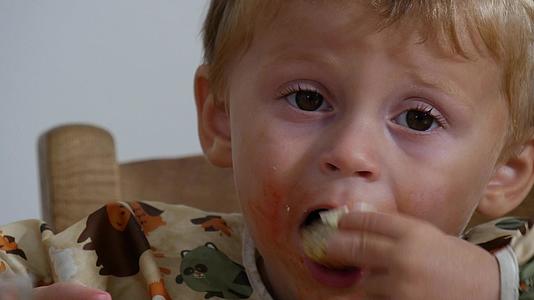 可爱的小可爱男孩吃面包和奶酪两年视频的预览图