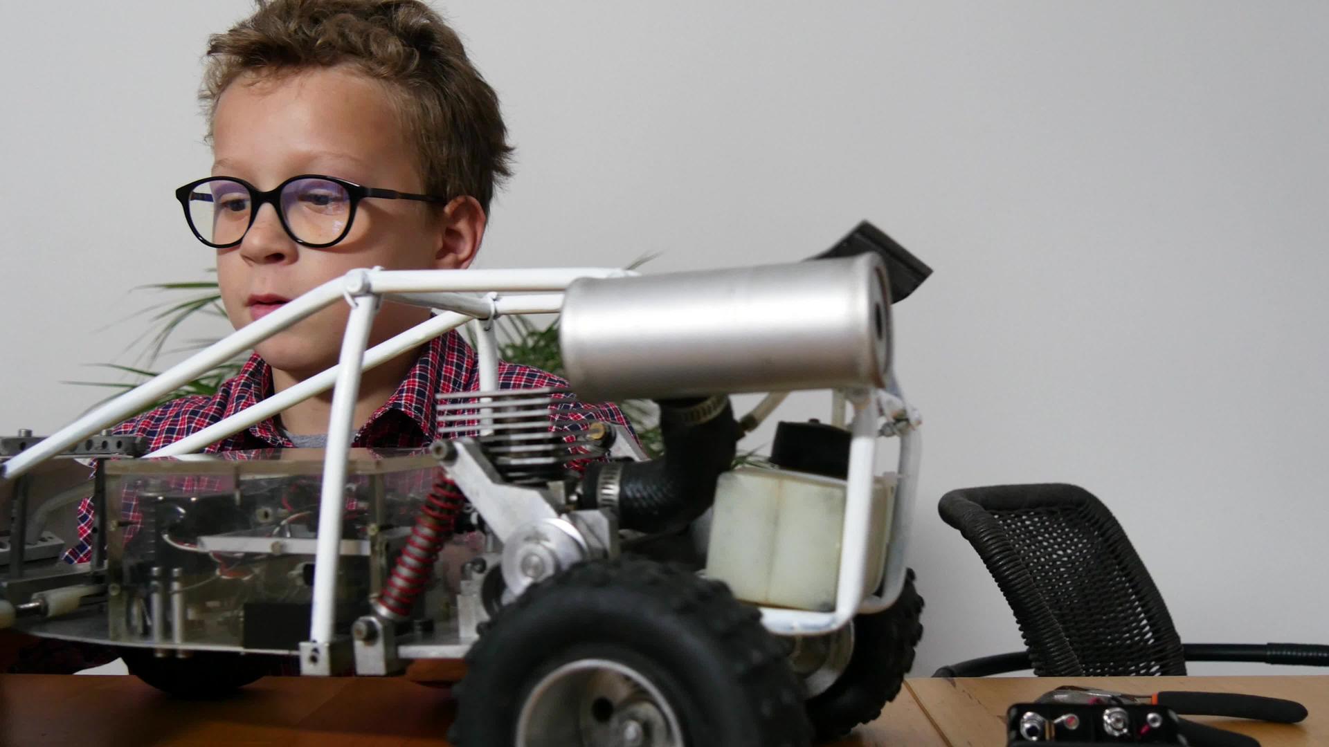 小男孩在家里修理一辆无线电控制车的模型视频的预览图