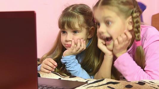 笔记本电脑屏幕上的一个有趣的点让孩子们感到非常高兴；在笔记本电脑上视频的预览图