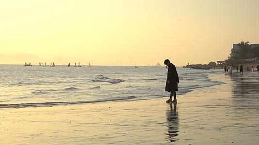 4K黄昏逆光男孩徘徊走在海滩视频的预览图