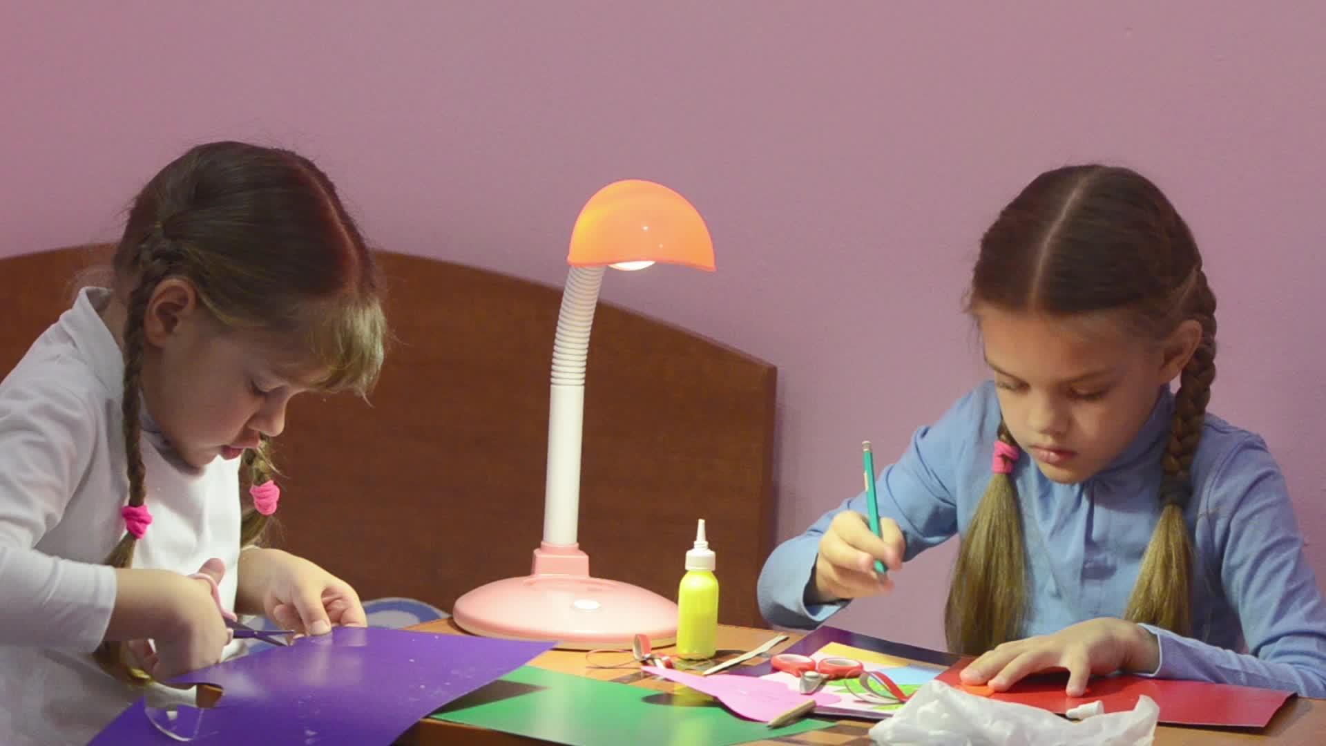 两个孩子做手工艺品剪刀切成剪刀彩色纸板第二个分数视频的预览图