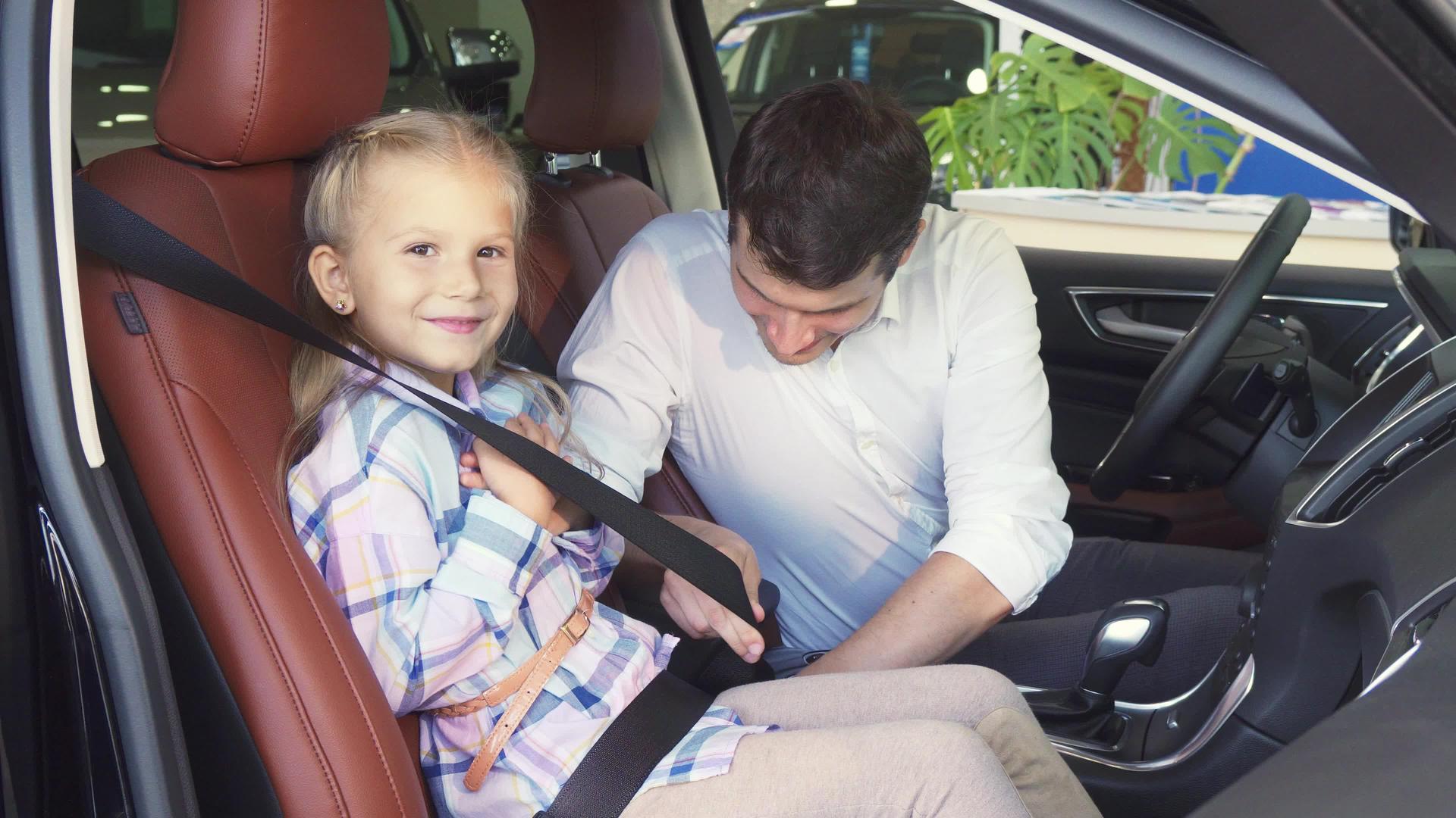 一位慈爱的父亲把女儿的安全带系在车里视频的预览图