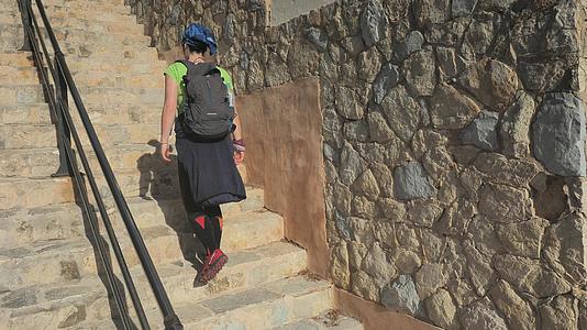 沿海建筑女性从海滩爬上薄楼梯到西班牙梅洛尔卡岛视频的预览图