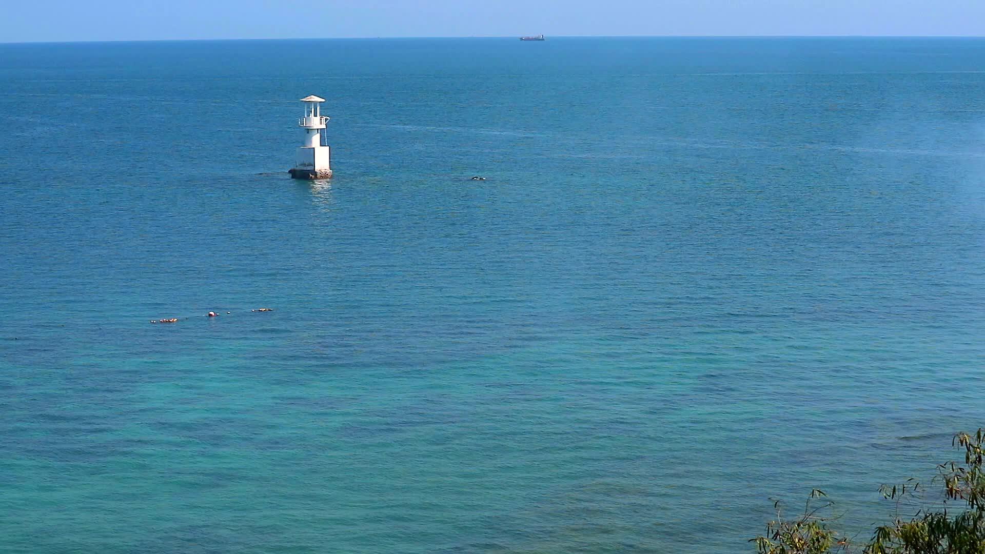 绿色海洋中的珊瑚礁被白色灯塔包围视频的预览图