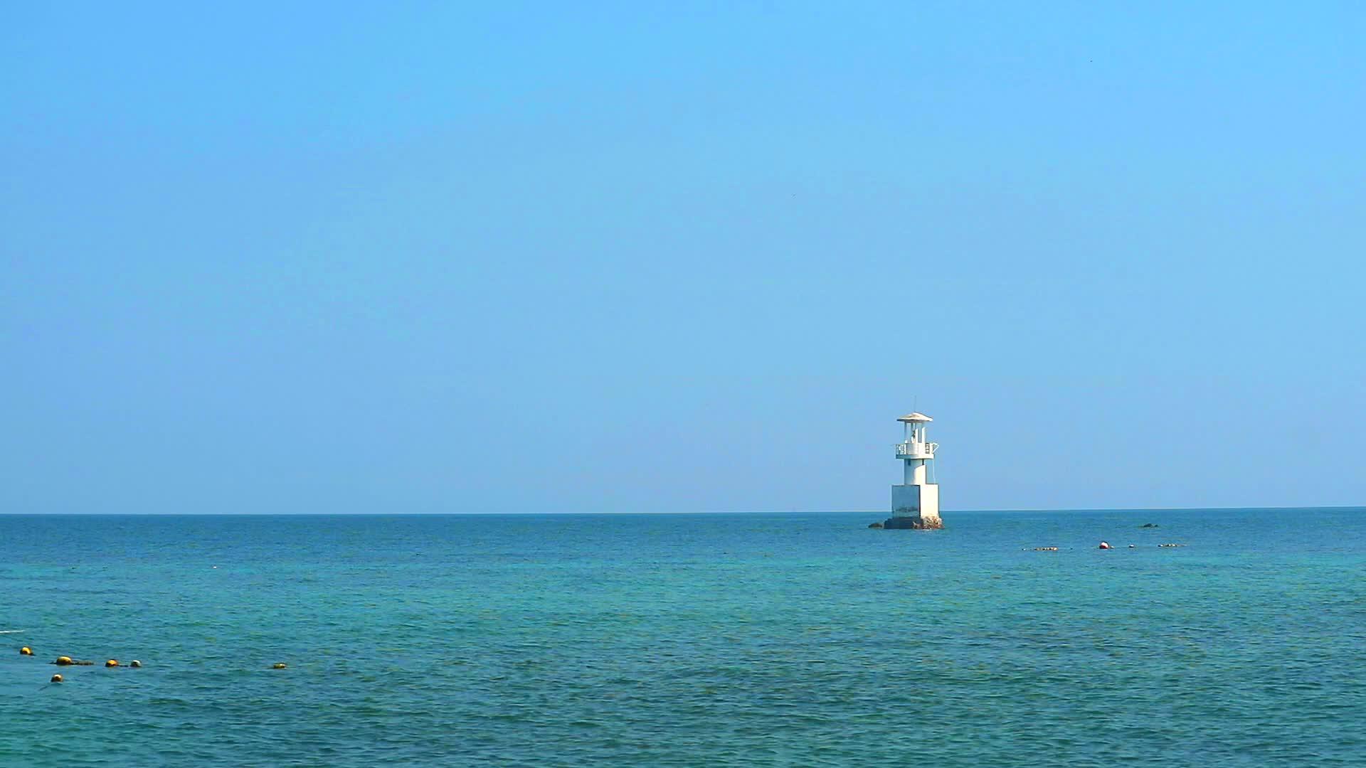 海洋中的珊瑚礁和蓝天环绕着白色的灯塔视频的预览图
