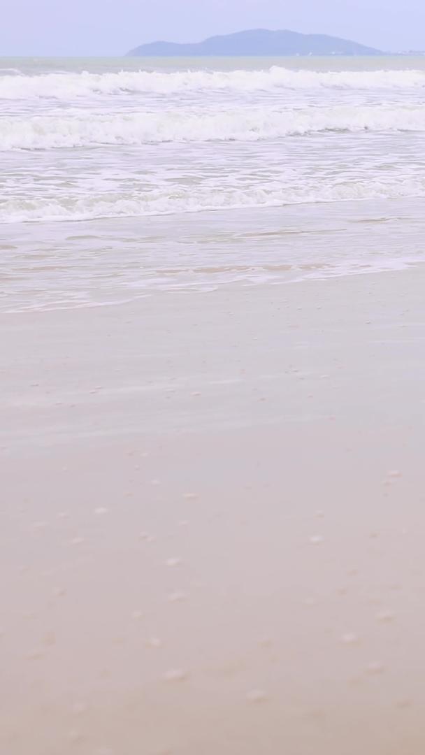 青年男性走在沙滩上的腿部特写视频的预览图