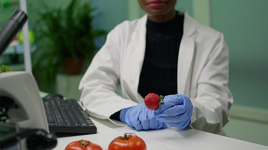 非洲化学家戴着医用眼镜在观看草莓注射化学农药时使用草莓视频的预览图