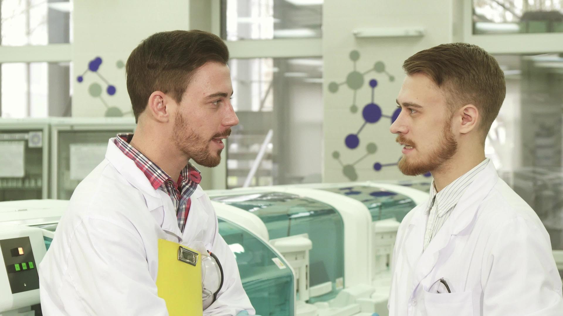 两位年轻的实验室技术人员站在实验室中间交谈视频的预览图