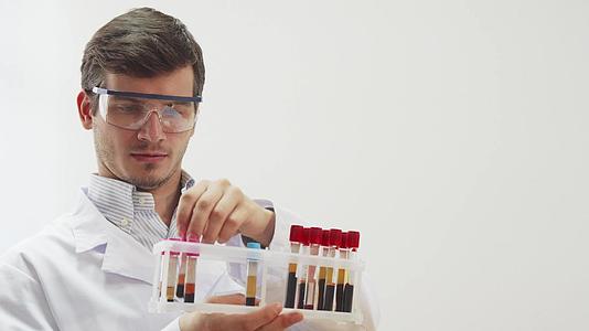 戴特殊实验室眼镜的医生用血液检查试管；检查时使用视频的预览图