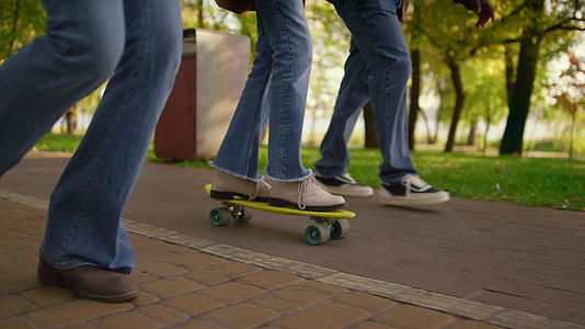 女孩腿上骑滑板的公园特写镜头视频的预览图
