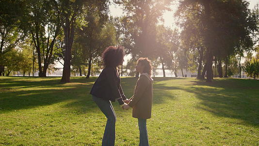 一家人手牵手摸鼻子在金色阳光公园的特写镜头里视频的预览图