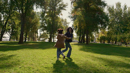 幸福的女儿在阳光明媚的公园里扮演母亲的角色视频的预览图