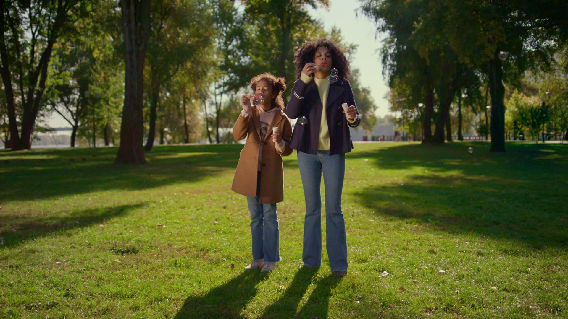 幸福的家庭一起吹肥皂泡站在绿色的田野里阳光明媚视频的预览图