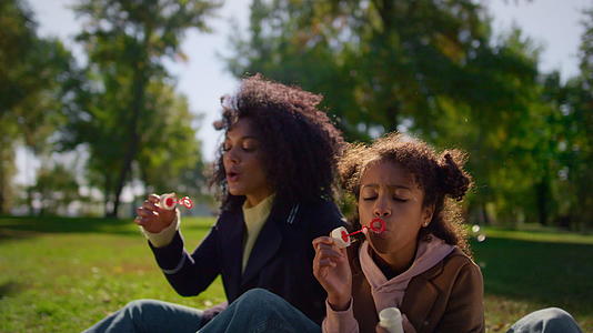 家庭吹气泡享受温暖的春天公园视频的预览图