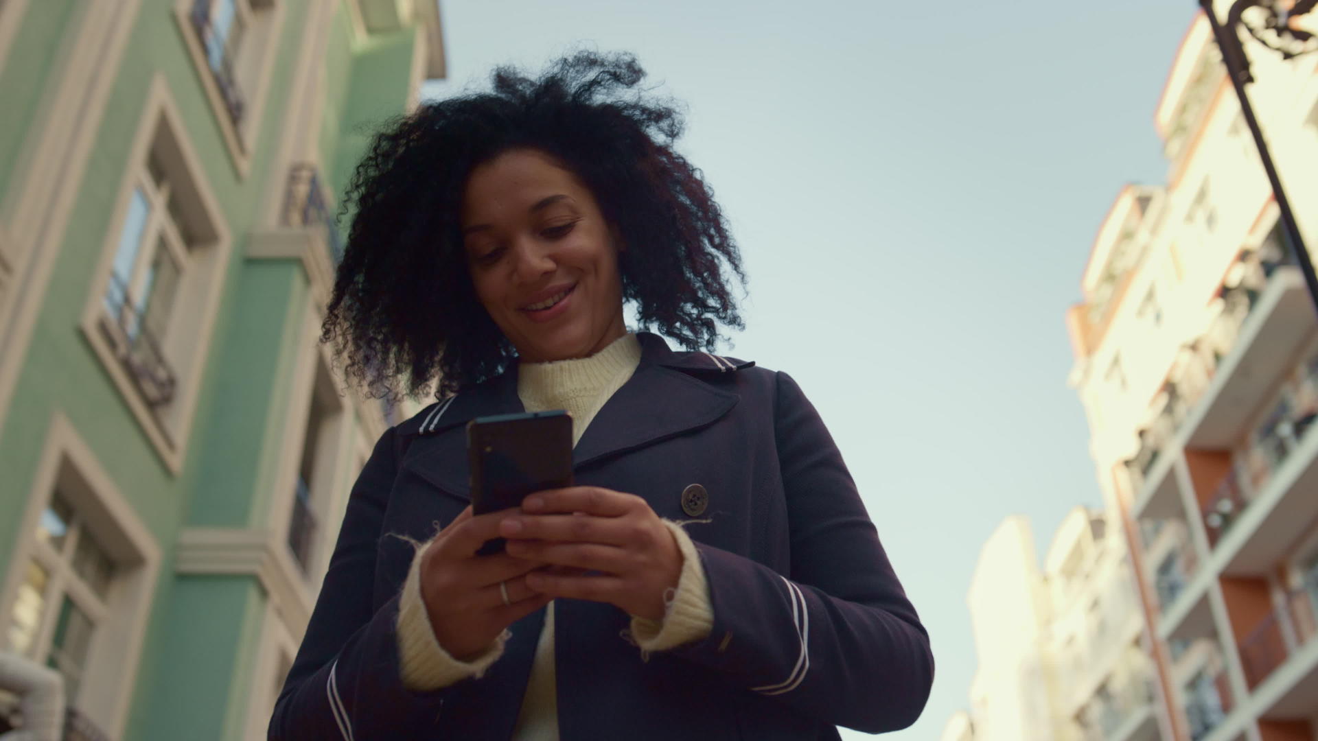 微笑的女人拿着智能手机走在阳光明媚的早晨视频的预览图
