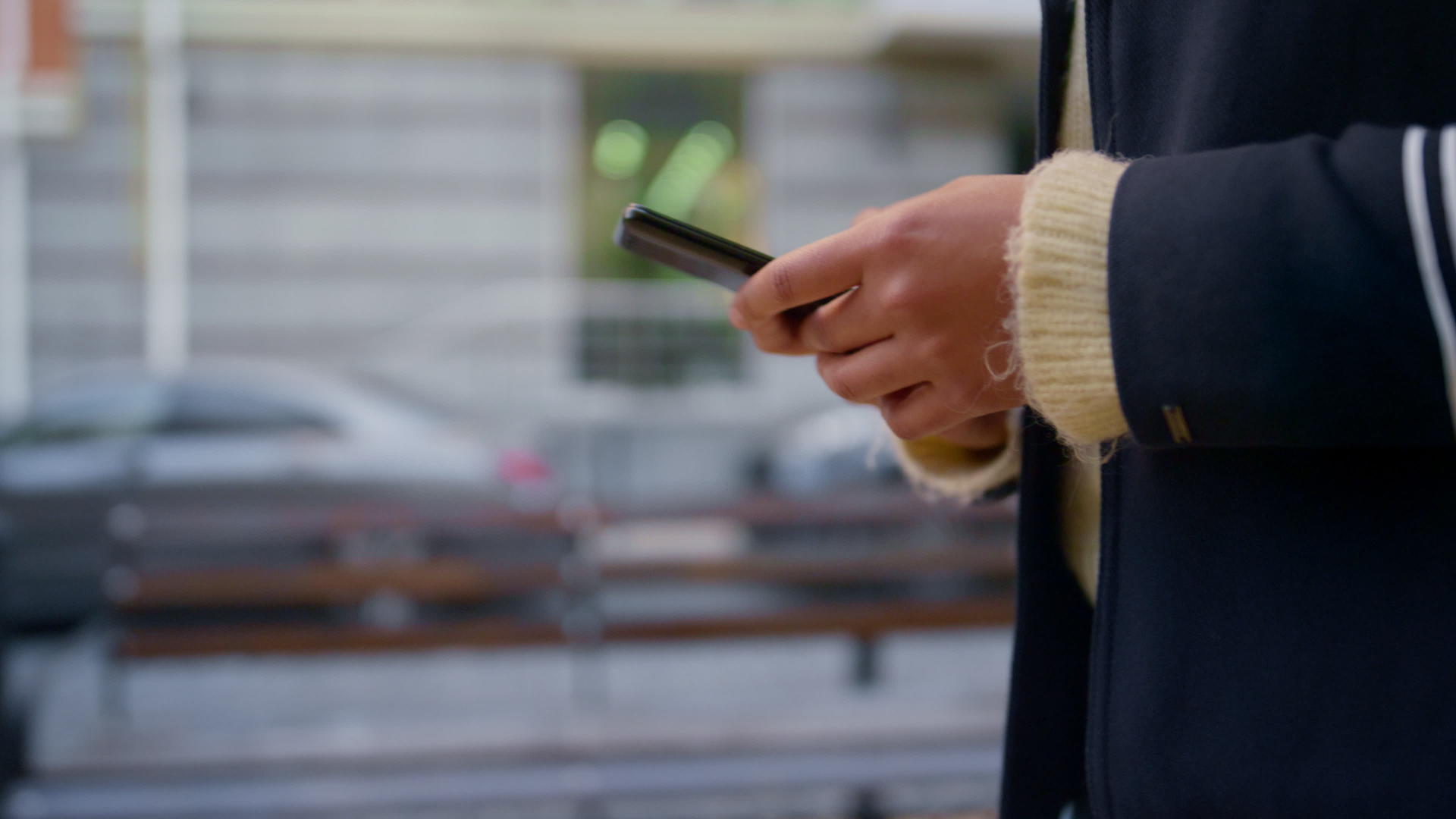 妇女手里拿着智能手机独自走在离焦的城市街道上视频的预览图