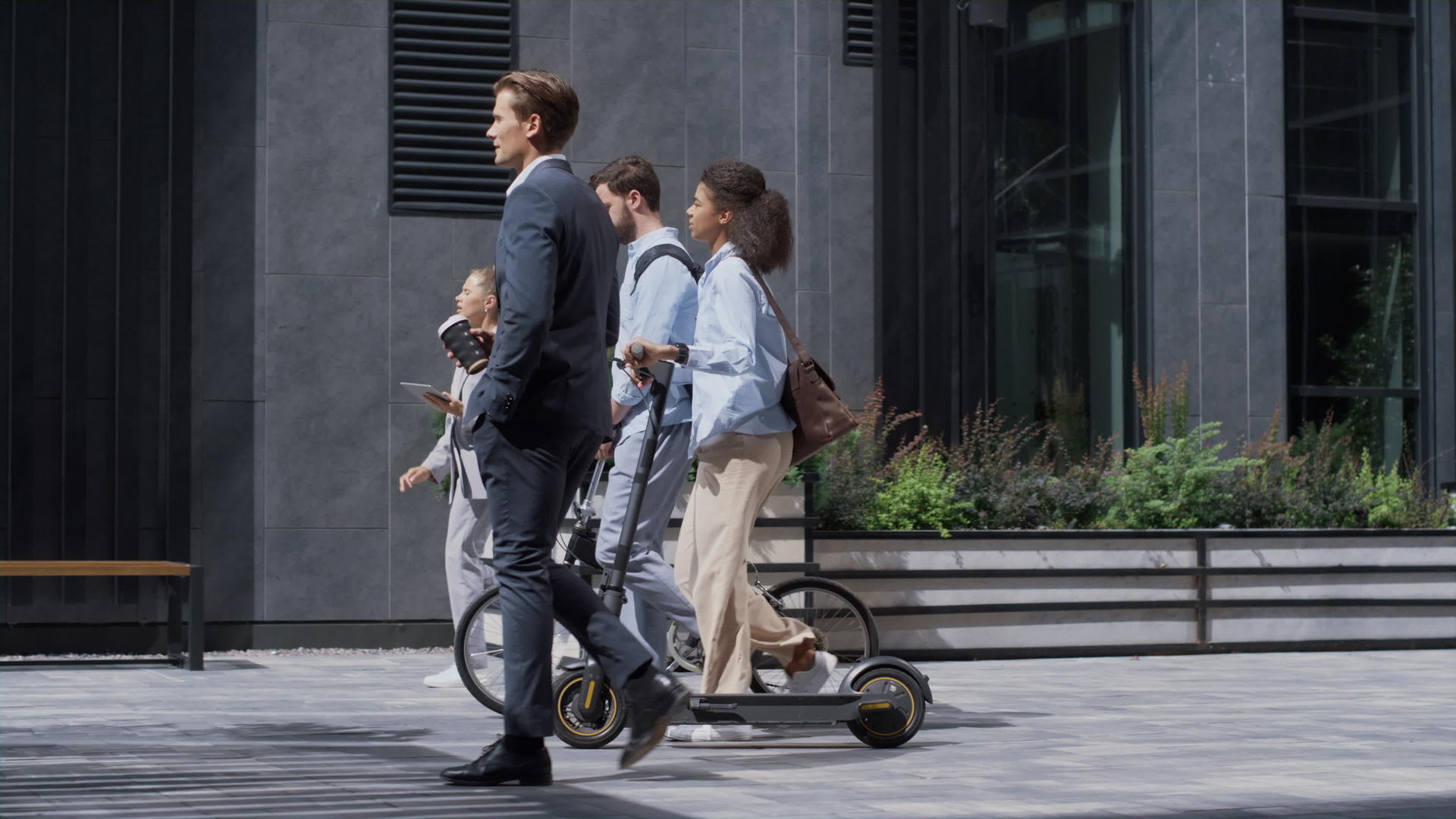 公司人士带着自行车电动踏板车步行到市中心视频的预览图