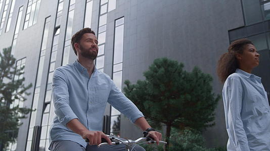 快乐的大胡子男人在市中心的街道上骑自行车视频的预览图