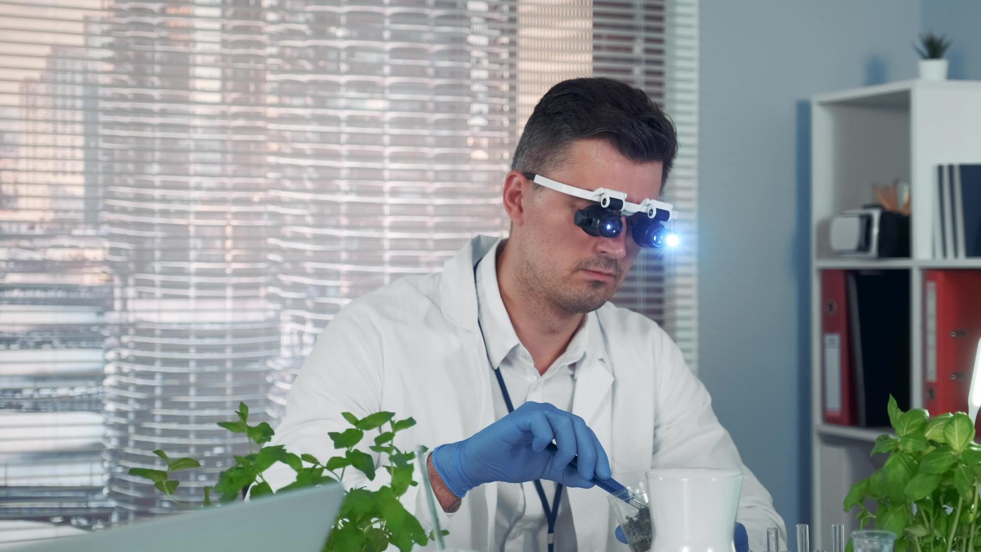 放大镜中的植物学家在大型现代实验室中学习植物视频的预览图