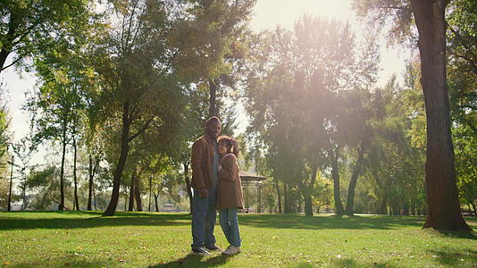 幸福的孩子父亲站在绿色的公园田野里金色的阳光下视频的预览图