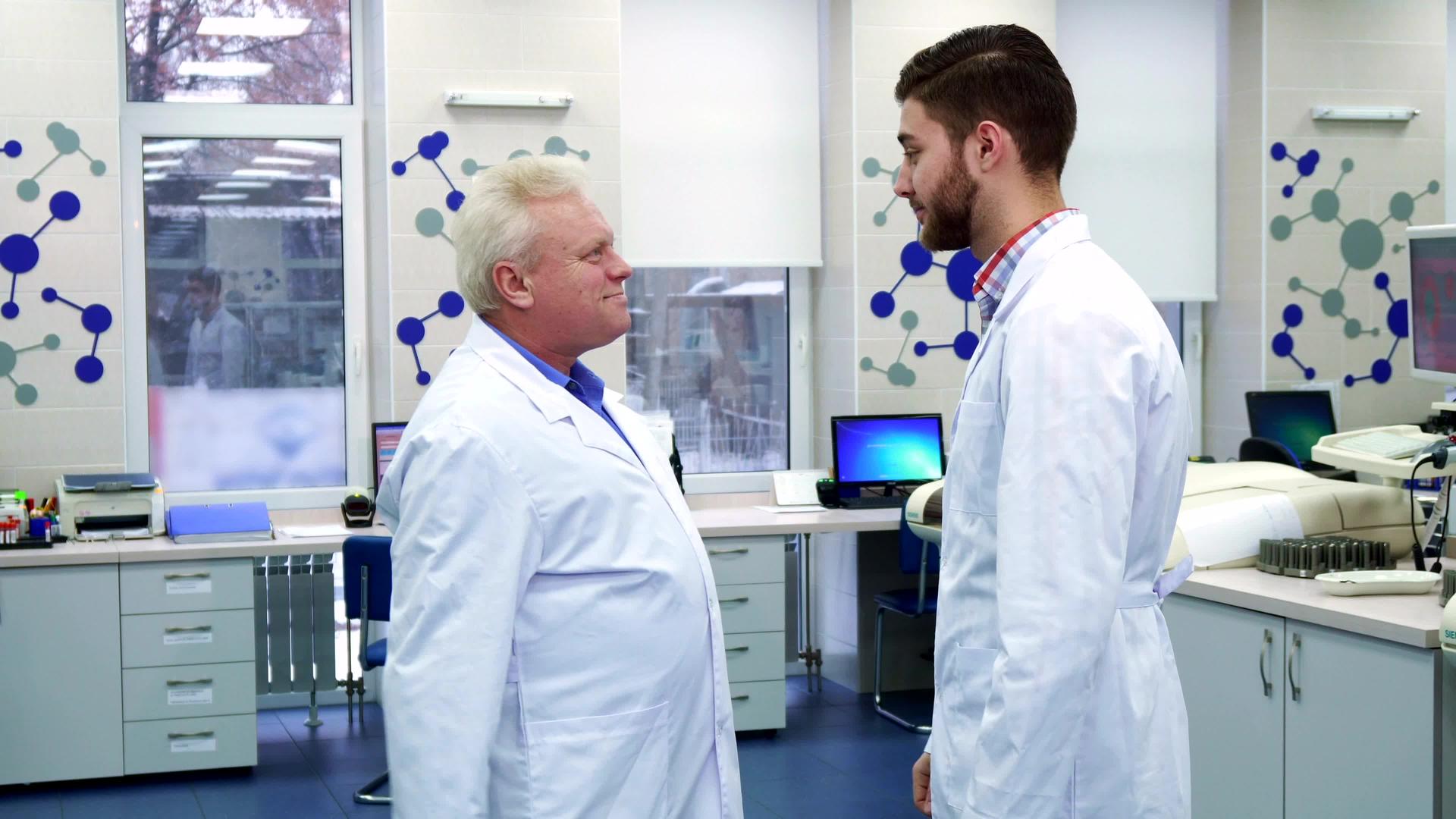 两名男性科学家在实验室互相打招呼视频的预览图