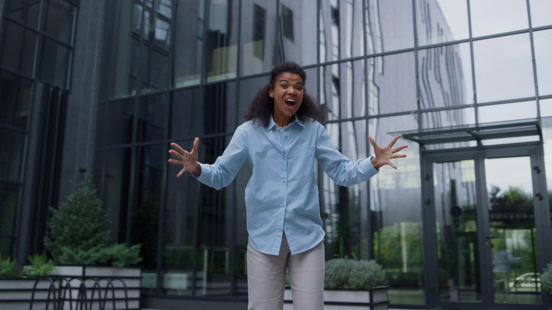 幸福的女人独自在现代商业中心的院子里跳舞庆祝胜利视频的预览图