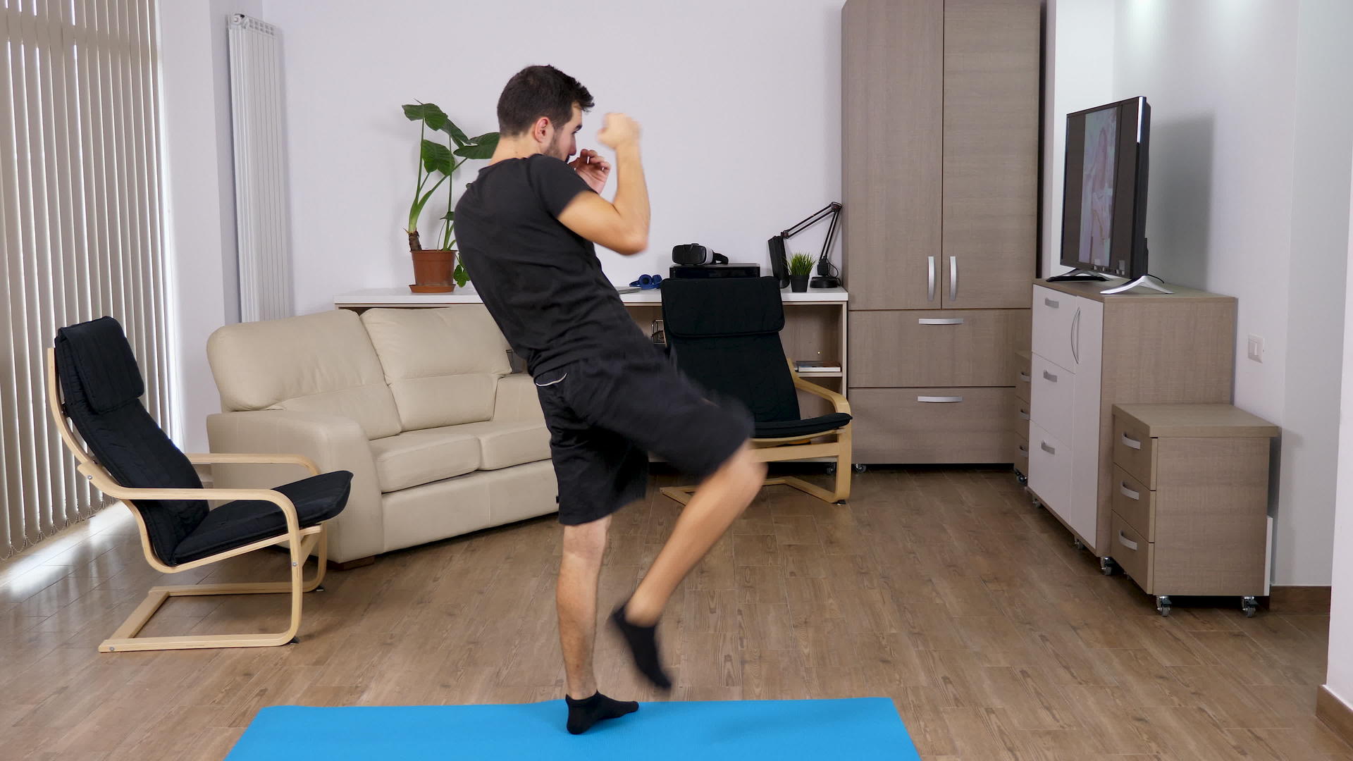 体育男子在客厅里踢拳打视频的预览图