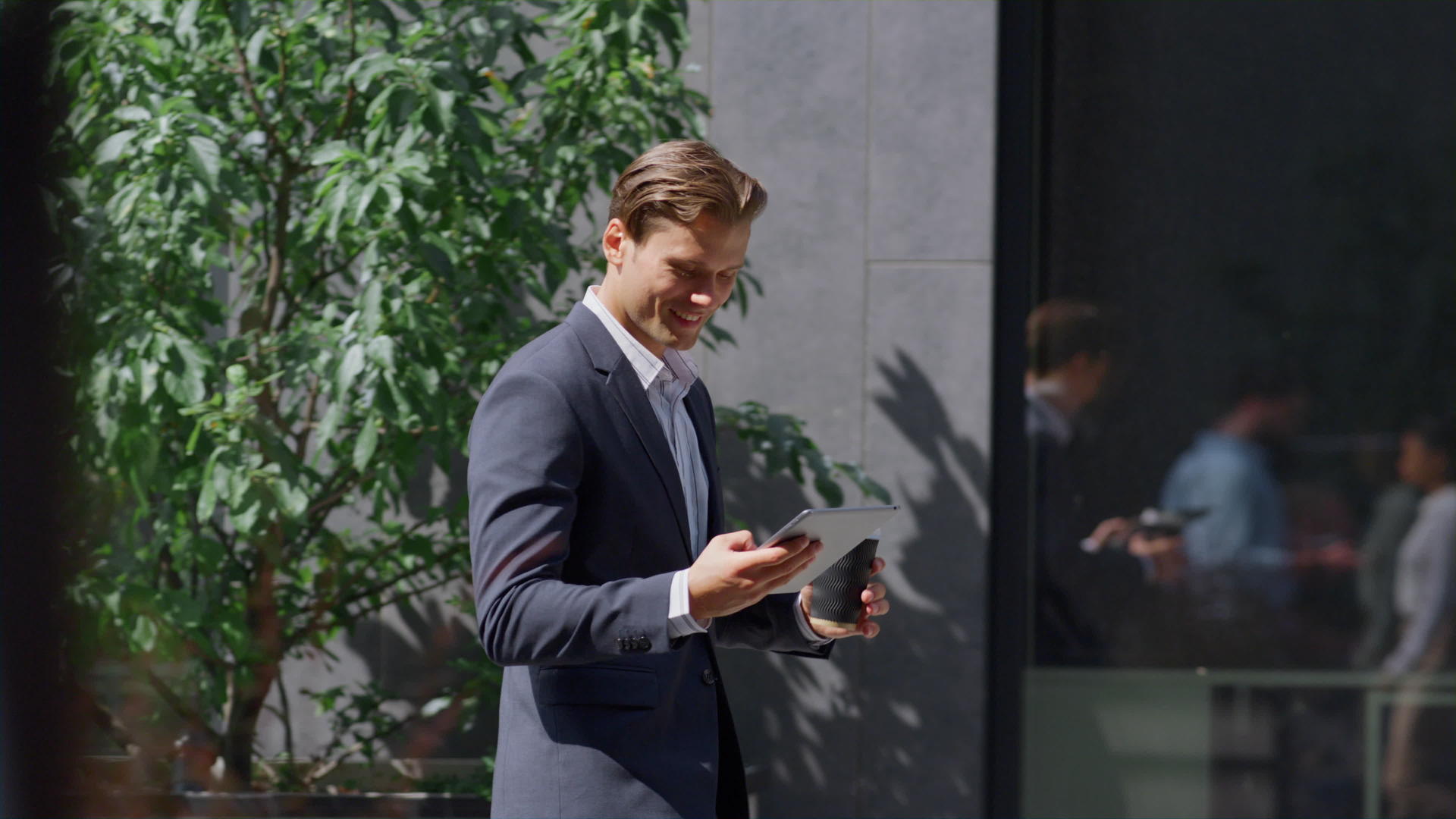 微笑着检查智能手机的财务人员走在外面的现代工作场所视频的预览图