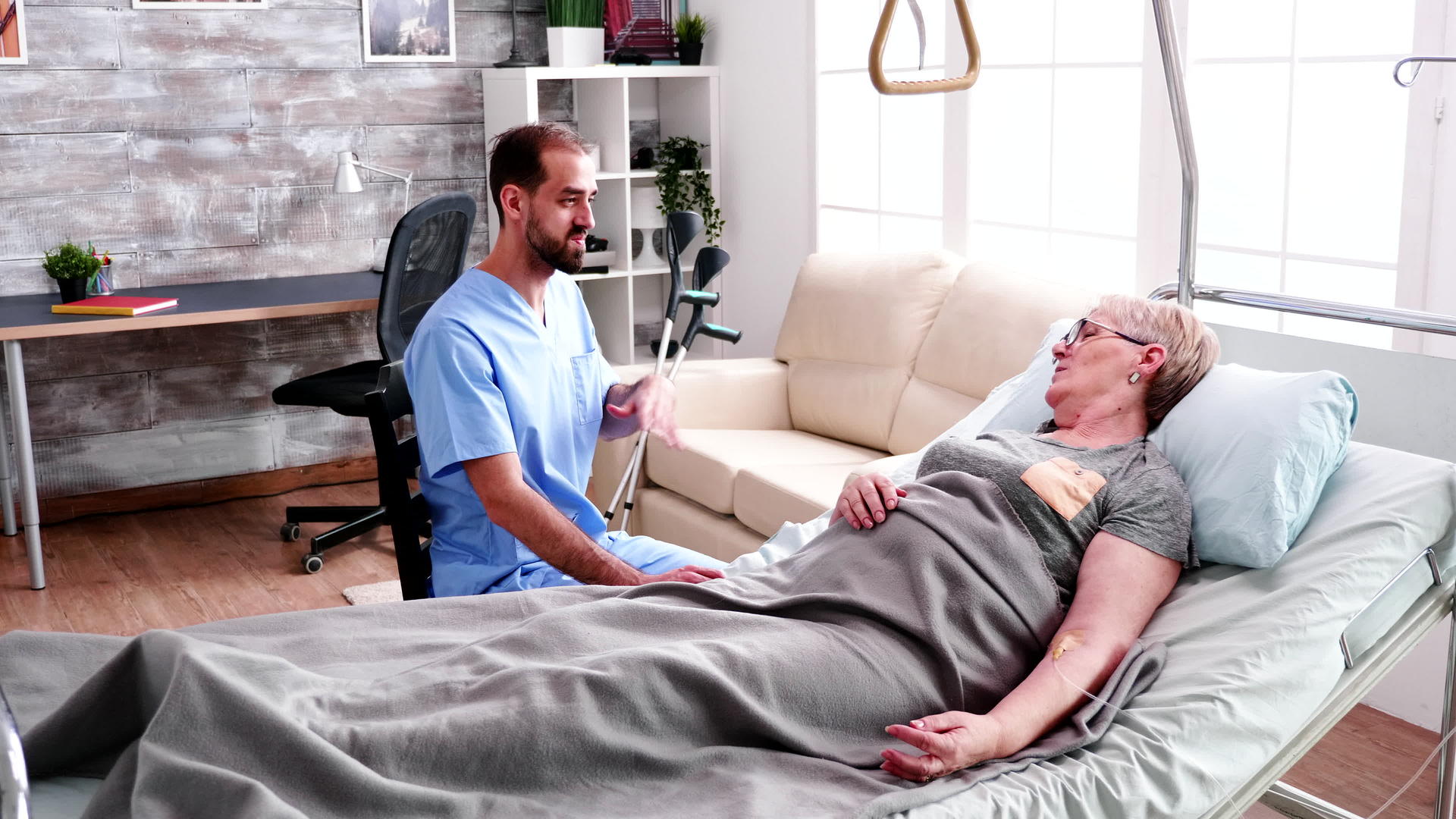 男护士看着躺在床上的老妇人视频的预览图