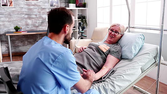 退休老妇女在养老院与男护士交谈视频的预览图