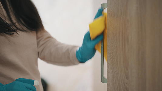 女性用消毒剂和湿毛巾关闭消毒门把手视频的预览图