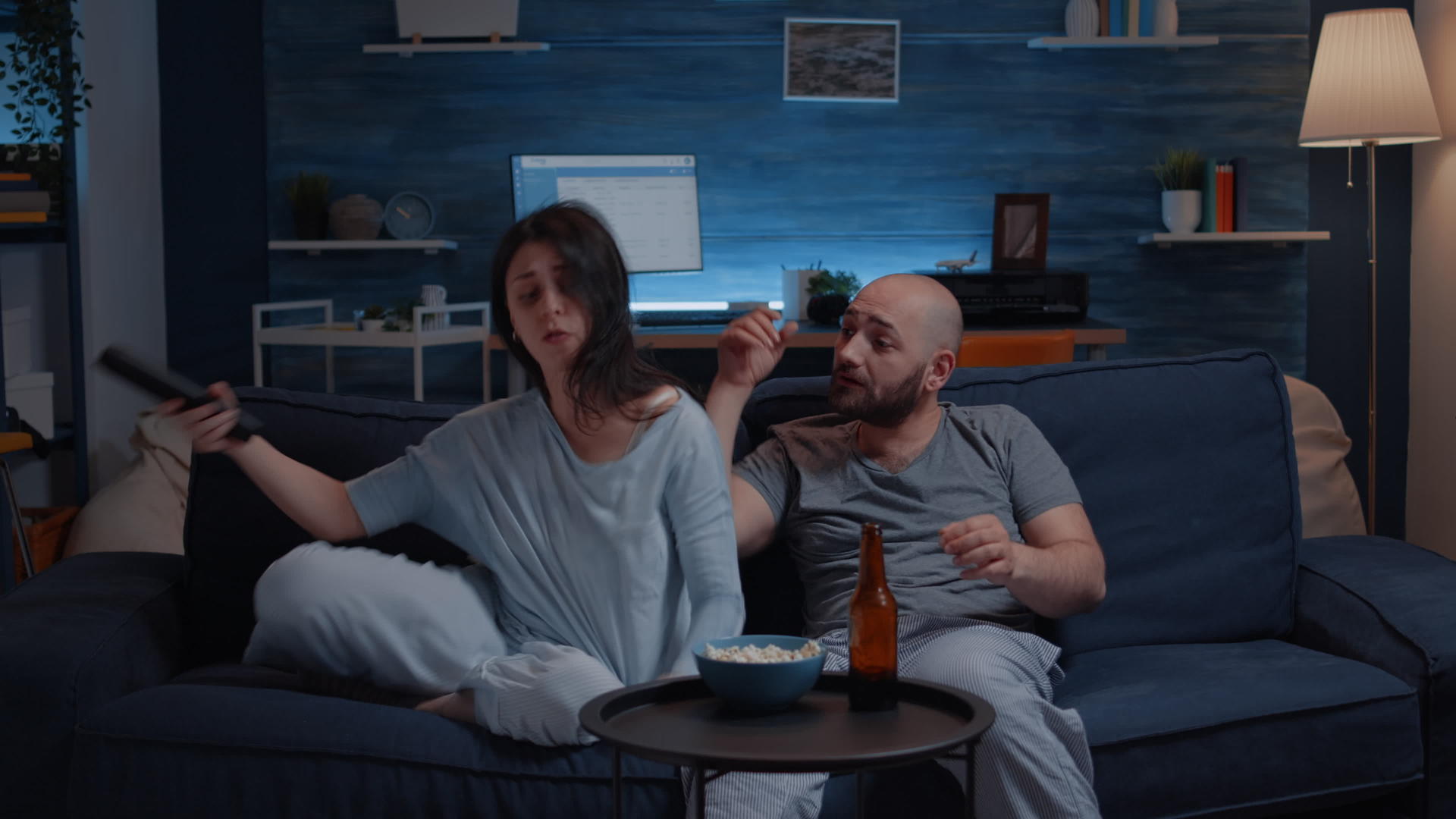 一对夫妇晚上穿着睡衣试图远程控制视频的预览图