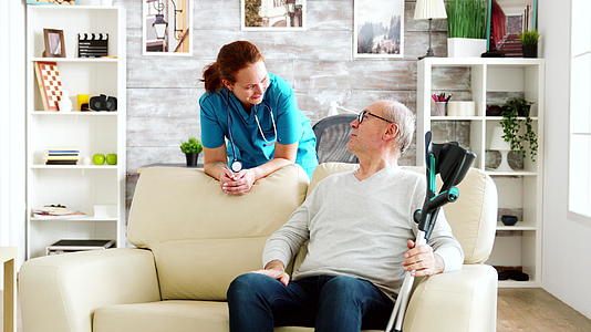 养老院的退休男子与护士交谈视频的预览图