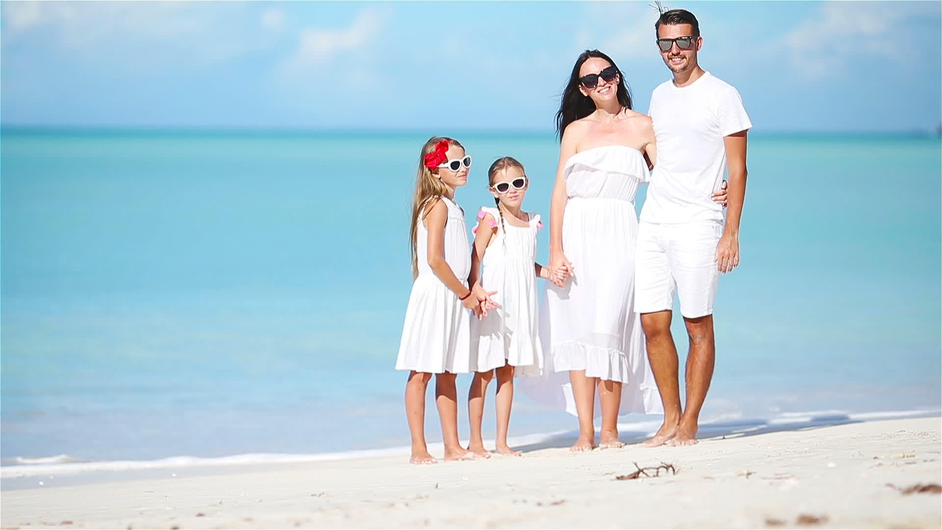 年轻家庭走在白色热带卡西比海滩上视频的预览图