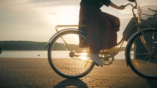 夕阳下海边逆光骑着自行车的人视频的预览图
