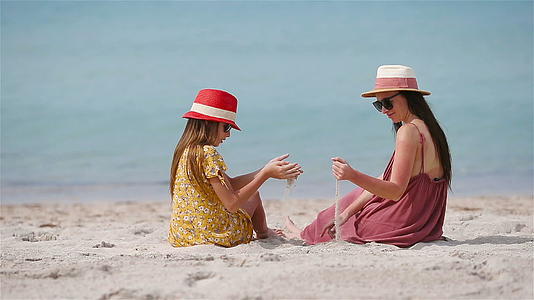 美丽的母亲和女儿在海滩上享受暑假视频的预览图