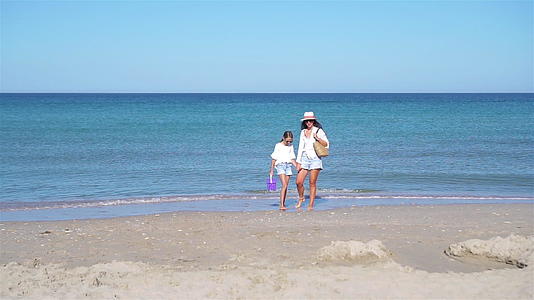 美丽的母亲和女儿在海滩上享受暑假视频的预览图