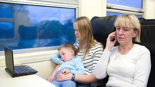 乘客在火车上观看笔记本电脑和电话的视频视频的预览图
