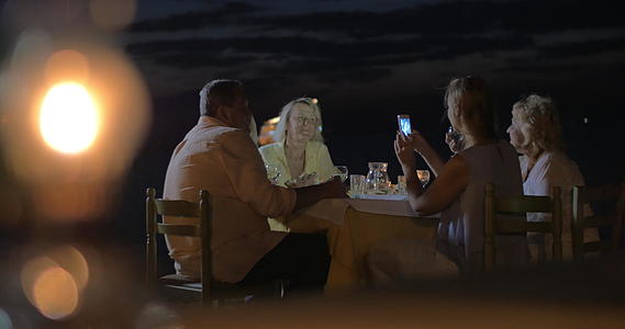 一家人晚上坐在城市的一张桌子上Pereagreeece视频的预览图