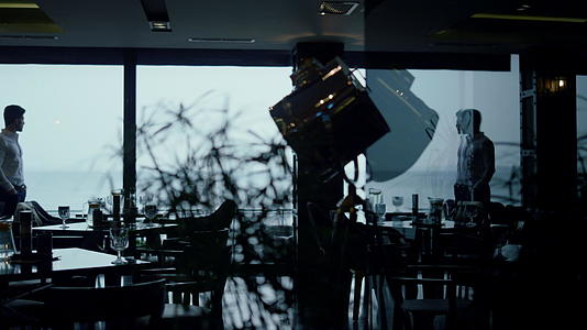帅哥剪影在经典的深色咖啡馆房间里度过时间视频的预览图