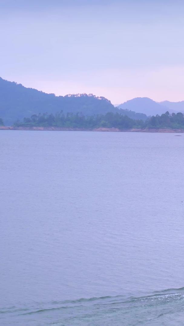 清晨宁静的湖面上开着渔船出去钓鱼的渔民视频的预览图