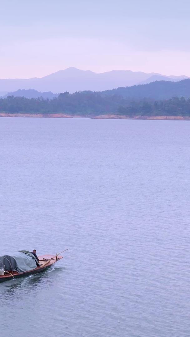 清晨宁静的湖面上开着渔船出去钓鱼的渔民视频的预览图
