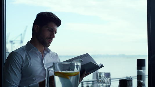 在全景豪华酒廊酒吧肖像中放松的男顾客阅读酒单视频的预览图